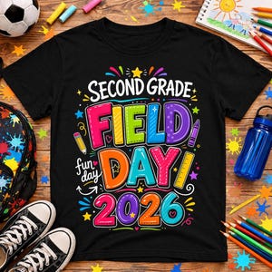 Può includere: T-shirt nero con una grafica colorata che recita "SECOND GRADE FIELD DAY 2026". Il design include stelle, una matita, un pastello e un righello. La maglietta è circondata da materiale scolastico, tra cui un pallone da calcio, uno zaino e scarpe da ginnastica.