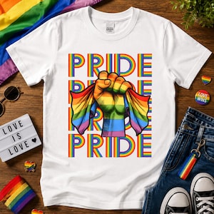 May include: White t-shirt with the word "PRIDE" in rainbow colors repeated vertically. A fist clenches a rainbow flag. The words "LOVE IS LOVE" are on a light-up sign. A rainbow flag and denim jeans are also in the image.