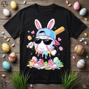 Puede incluir: Camiseta negra con un personaje de béisbol con gafas de sol, gorra azul y orejas de conejo, sosteniendo un bate. El diseño incluye huevos de Pascua y corazones. El personaje lleva zapatillas rosas.