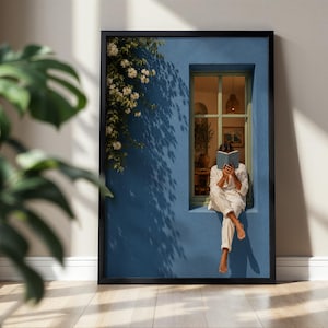Puede incluir: Una impresión de arte mural enmarcada que muestra a una persona con ropa blanca sentada en el borde de una pared azul junto a una ventana, leyendo un libro. Una planta trepadora con flores blancas crece en la pared azul, proyectando sombras.