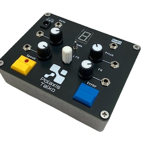 Può includere: Un dispositivo elettronico nero con più manopole, pulsanti e porte. Il dispositivo ha un pulsante giallo con l'etichetta "Speak" e un pulsante blu con l'etichetta "Error". Il testo "Polaxis Talko" è stampato sul dispositivo.