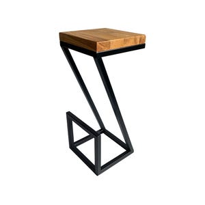 Könnte beinhalten: Ein moderner Beistelltisch mit einer rechteckigen, hellbraunen Holzplatte. Der Tisch hat ein schwarzes, geometrisches Metallgestell. Der Rahmen hat ein Z-förmiges Design mit quadratischer Basis und schafft einen einzigartigen und stilvollen Look.