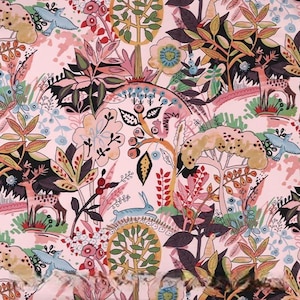May include: A whimsical fabric design featuring a pink background with a repeating pattern of trees, deer, birds, and flowers in shades of pink, green, blue, and brown. The illustration has a hand-drawn aesthetic.