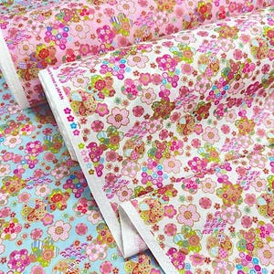 以下が含まれることがあります： 花柄の生地が3ロール。ピンク、赤、黄色の花が白い背景に繰り返されるデザインです。1つのロールは薄いピンク、もう1つは水色、3つ目は白です。「Made in Japan」の文字が見えます。