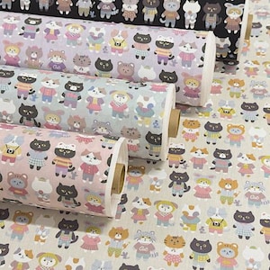 以下が含まれることがあります： カラフルな服を着た漫画の猫の繰り返し模様が特徴の布ロール。猫は黒、白、茶色、灰色など様々な色で描かれており、パステルカラーの背景にセーター、スカート、オーバーオールを着た姿がプリントされています。