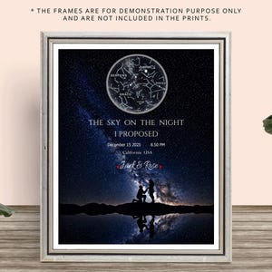 May include: Framed print featuring a starry night sky with a constellation map. The text reads "THE SKY ON THE NIGHT I PROPOSED" with a date, time, and location. A silhouette of a couple is kneeling in front of a body of water.