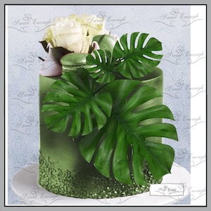 Könnte beinhalten: Ein grüner Kuchen, verziert mit großen, leuchtend grünen Monstera-Blättern. Der Kuchen ist mit weißen Rosen, grünen Makronen und einer kleinen rosa Teekanne geschmückt. Der Boden des Kuchens hat ein glitzerndes grünes Design. Der Text "Sweet Enough" ist im Bild.