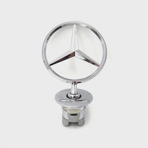 Può includere: Ornamento cromato per cofano Mercedes-Benz. L'emblema presenta una stella a tre punte all'interno di un cerchio, montata su una base cilindrica. L'ornamento è progettato per i cofani dei veicoli. Misure in centimetri.