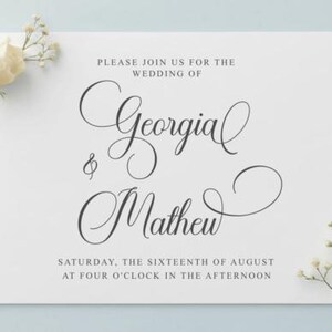 May include: A white wedding invitation with elegant script announcing the wedding of Georgia and Mathew. The text is in black, with the date and time also included. A white rose and sprigs of baby's breath are in the corners.