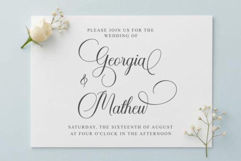 May include: A white wedding invitation with elegant script announcing the wedding of Georgia and Mathew. The text is in black, with the date and time also included. A white rose and sprigs of baby's breath are in the corners.