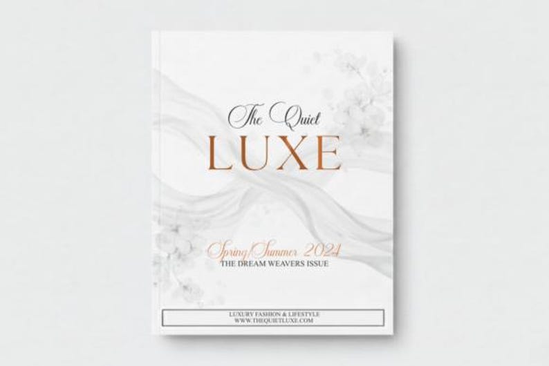 May include: A white magazine cover with the title "The Quiet LUXE" in elegant typography. The cover features a flowing, abstract design and the text "Spring Summer 2024". The magazine is focused on luxury fashion and lifestyle.