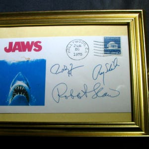 Framed JAWS Movie Commemorative Envelope featuring Facisimile signatures of  Shaw, Scheider and Dreyfuss plus JAWS enamel promo pin.