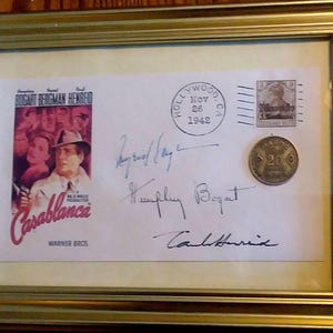 Sobre conmemorativo de la película CASABLANCA enmarcado con firmas facsímiles de Bogart, Bergman y Henreid, sello raro y moneda marroquí.