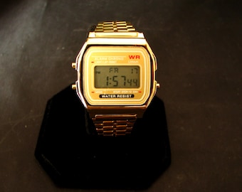 Reloj digital retro vintage con pantalla LCD. Alarma/cronógrafo multifunción. Funcionamiento impecable con batería nueva y funda de terciopelo. Tono dorado.