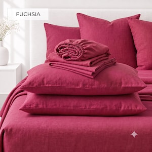May include: A fuchsia bedding set featuring a flat sheet, a fitted sheet, and two pillowcases. The fabric has a visible woven texture. The text FUCHSIA is displayed in a white box in the upper left corner of the image, indicating the color.