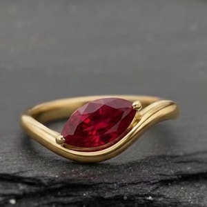 May include: A white ceramic mug with a black handle and the text "But First, Coffee" in a black, bold font. The mug is on a white surface.