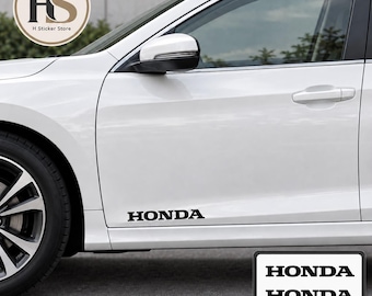 Puede incluir: Un juego de dos calcomanías de vinilo negro con la palabra HONDA en una fuente en mayúsculas negrita. Las pegatinas están diseñadas para su aplicación en el panel lateral inferior de un coche blanco, como se muestra, e incluyen el texto 2 PIECES.