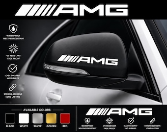 Puede incluir: Una calcomanía blanca de AMG aplicada en un espejo lateral de coche negro. El gráfico muestra el logo de AMG con cinco barras inclinadas. Iconos de texto indican características como impermeable, resistente a la intemperie, UV y adhesivo.