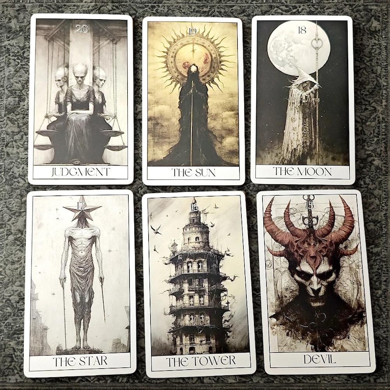 Peut inclure: Six cartes de tarot avec des illustrations en noir et blanc. Les cartes incluent "Jugement", "Le Soleil", "La Lune", "L'&Eacute;toile", "La Tour" et "Le Diable". Chaque carte pr&eacute;sente des illustrations et du texte uniques.