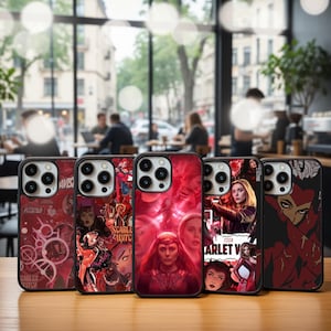 May include: A collection of phone cases featuring various designs and graphics. The cases showcase images of a character from a comic book series, with a red and black color scheme. The cases are displayed on a wooden surface.