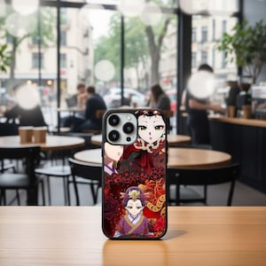 May include: Black phone case featuring a colorful anime-style illustration. The design includes multiple female characters in traditional attire, set against a red and gold floral background. The case is shown on a wooden table.