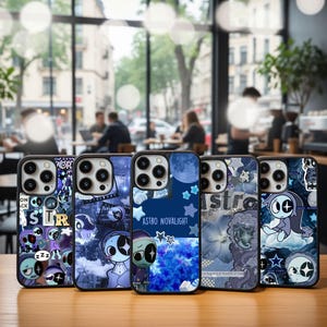 Może przedstawiać: Kolekcja pięciu etui na telefon o unikalnych wzorach. Każde etui ma ciemne tło z postaciami z kreskówek, gwiazdami i tekstem "astro". Etui mają błyszczące wykończenie i są prezentowane na drewnianej powierzchni.