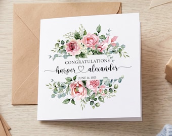 May include: A square white greeting card featuring a watercolor floral arrangement of pink roses and green eucalyptus leaves. The text reads CONGRATULATIONS, harper, a heart symbol, alexander, and JUNE 14, 1025, centered between the floral clusters.