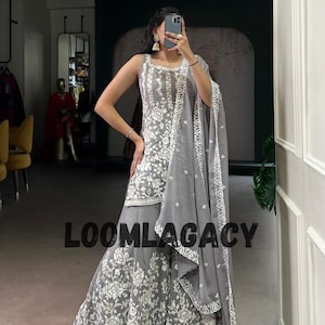May include: A grey sleeveless outfit with detailed white floral embroidery. The set comprises a top, wide-leg trousers, and a matching scarf. The text "LOOMLAGACY" is printed across the image.