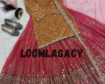 May include: An orange and pink embroidered ensemble featuring a long-sleeved top and a flowing skirt. The outfit is adorned with intricate gold detailing and embellishments. The skirt has a gradient effect, transitioning from a deep pink to a lighter shade. The text "LOOMLAGACY" is visible.