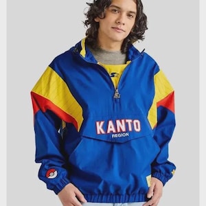 May include: Blue, yellow, and red Kanto Region Starter jacket. The jacket has a half-zip closure, a front pocket, and the word "KANTO" in red block letters. A Pokemon ball logo is on the left sleeve.
