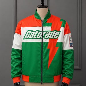 Könnte beinhalten: Eine Bomberjacke mit Reißverschluss in einem Color-Block-Design aus Grün, Weiß und Orange. Die Vorderseite zeigt das Gatorade-Logo in grüner Schrift auf einem weißen horizontalen Streifen und ein großes orangefarbenes Blitzmotiv auf der linken Seite.