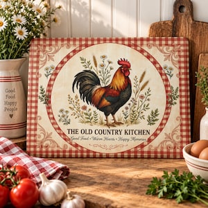 Puede incluir: Una tabla de cortar rectangular con una ilustración central de un gallo rodeado de trigo y margaritas, enmarcada por un borde de cuadros rojos y blancos. El texto dice THE OLD COUNTRY KITCHEN, Good Food, Warm Hearts, Happy Memories.