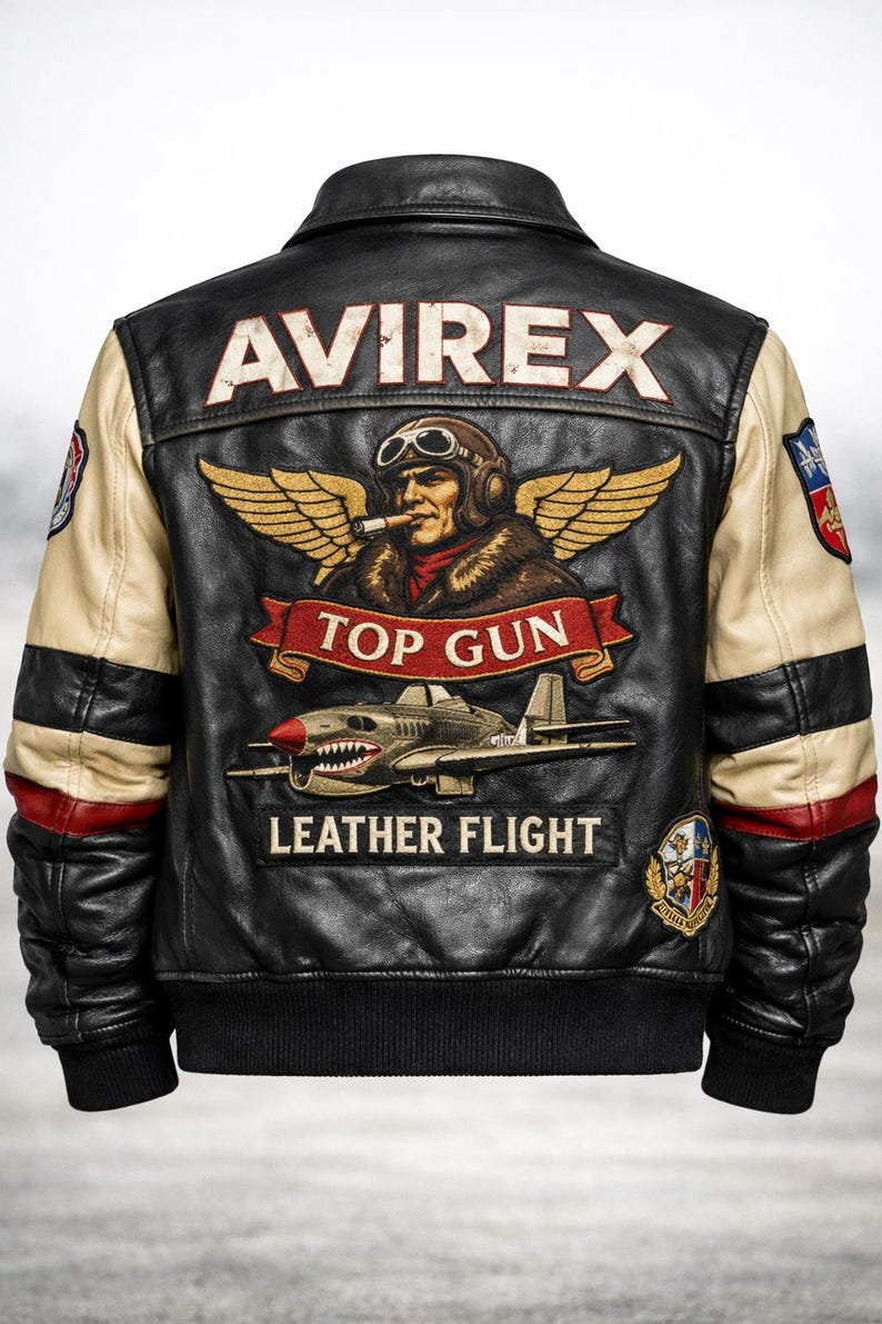 May include: A black leather flight jacket with cream-colored sleeves featuring red accents. The back displays an embroidered pilot with wings, the text AVIREX, TOP GUN, and LEATHER FLIGHT, along with a fighter plane graphic and various circular patches.