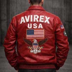 May include: A red leather jacket featuring the white text AVIREX USA on the back, a large embroidered American flag, and a bald eagle emblem with the text U.S.A. below it. The sleeves include a small American flag patch and a circular logo patch.