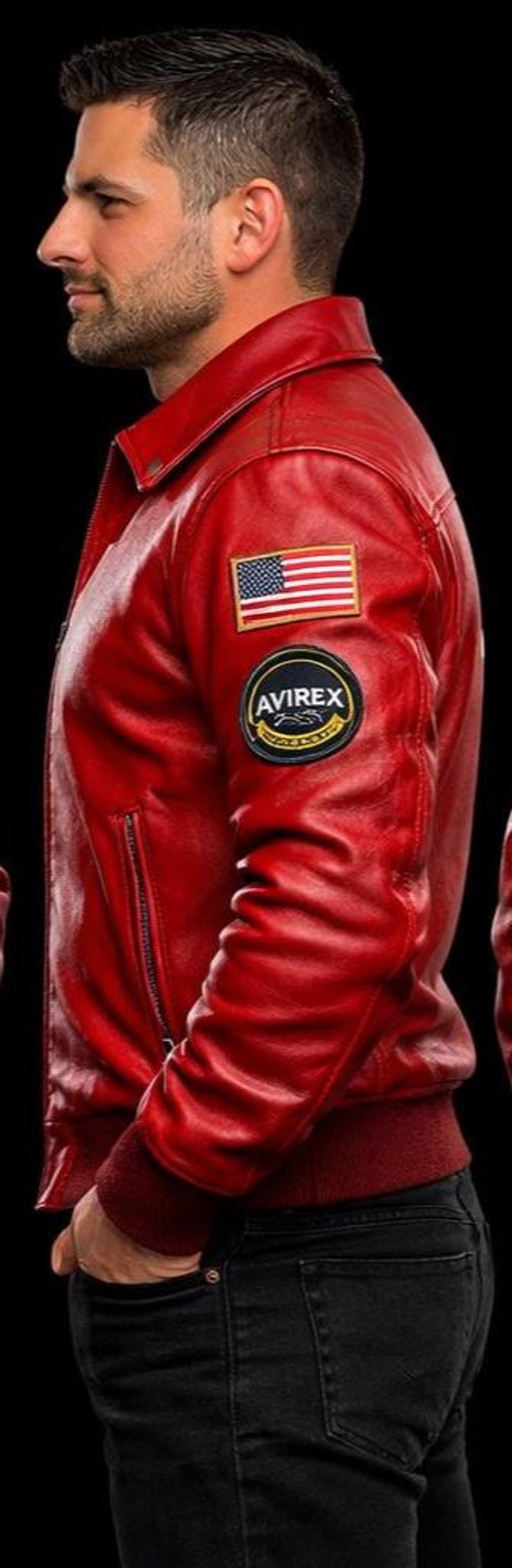 May include: A bright red leather jacket featuring a classic collar, a zippered side pocket, and a ribbed hem. The left sleeve displays a rectangular American flag patch positioned above a circular black and gold patch with the text AVIREX.