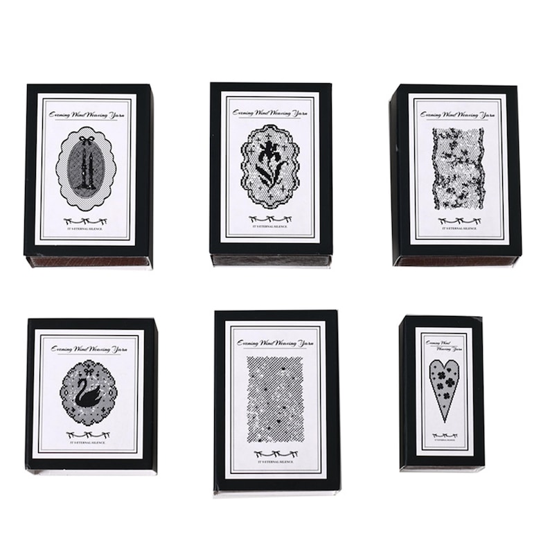 May include: Six rectangular black boxes with white labels featuring the text Evening Wind Weaving Yarn and A ETERNAL SILENCE. The labels display black and white illustrations of candles, a flower, lace, a swan, stars, and a heart shape.