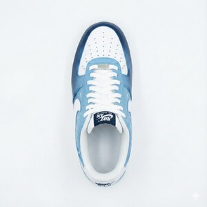 Puede incluir: Vista superior de una zapatilla Nike Air Force 1 azul claro y blanca. La zapatilla presenta una puntera blanca con peque&ntilde;as perforaciones, cordones blancos y un logotipo de Nike azul marino en la leng&uuml;eta. Los laterales y el tal&oacute;n son de color azul claro con detalles blancos.