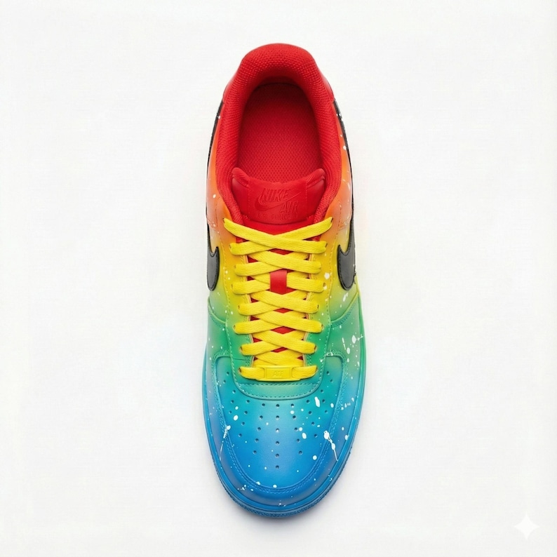 Pode incluir: Vista de cima de um t&ecirc;nis colorido. O t&ecirc;nis apresenta um design gradiente, que transita do vermelho para o amarelo, verde e azul. Salpicos de tinta branca adicionam detalhes. O swoosh preto da Nike e os cadar&ccedil;os amarelos completam o design.