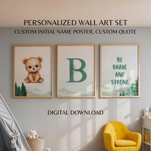 Könnte beinhalten: Ein Set aus drei gerahmten Wandkunstdrucken. Der erste zeigt eine niedliche Bärenillustration, der zweite einen großen Buchstaben "B" mit "Bear" in Schrift, und der dritte lautet "Be Brave and Strong". Alle in Holzrahmen.