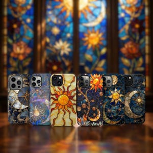 May include: A collection of six phone cases with stained glass designs. The cases feature celestial motifs like suns, moons, and stars in shades of yellow, orange, blue, and gold. The cases are displayed against a blurred background of a stained glass window.