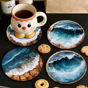 May include: Four round coasters with a wave design, featuring shades of blue and white, with a wooden border. A whimsical mug with a face design sits on one coaster. Cookies are scattered around the coasters.