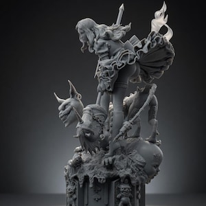 May include: A gray resin figurine depicting a character with long hair holding a long staff, standing atop a base decorated with card suit symbols and small figures. The character wears a ruffled skirt and boots, surrounded by a horned creature and a doll head.