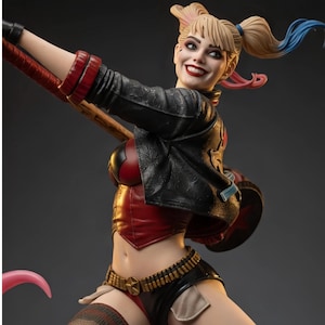 May include: A detailed figurine of a smiling character with blonde pigtails featuring blue and pink tips. The figure wears a black textured jacket over a red corset, black shorts with a gold star belt, and holds a large mallet over the shoulder.