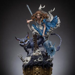 May include: A detailed figurine featuring a brown-haired character in a blue dress and white apron, holding a knife and a long staff. Beside them is a grinning purple cat-like creature, all standing atop a base of doll heads and a gold emblem.