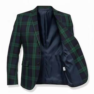 Può includere: Un blazer a quadri verdi e blu navy con chiusura a due bottoni. L'interno del blazer è foderato con un tessuto blu navy a tinta unita. La giacca è aperta, rivelando la fodera interna e il design su misura.