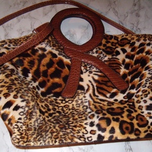 Bolso enorme, estampado animal peludo, piel sintética, bandolera extraíble, 40,6 cm de ancho x 38,1 cm de alto, numerosos compartimentos con cremallera, asa grande, como nuevo.