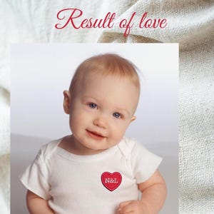 Könnte beinhalten: Ein weißer Babybody mit einem kleinen roten gestickten Herz auf der Brust, das den weißen Text N&L enthält. Über dem Baby steht der Text Result of love in einer roten Schreibschrift vor einem strukturierten, cremeweißen Stoffhintergrund.