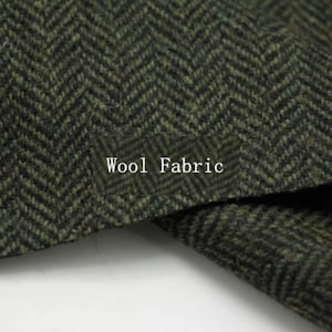 May include: Close-up of a textured wool fabric with a herringbone pattern in shades of green and black. The words "Wool Fabric" are printed in white on the fabric.