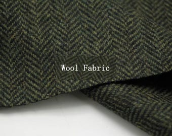 May include: Close-up of a textured wool fabric with a herringbone pattern in shades of green and black. The words "Wool Fabric" are printed in white on the fabric.