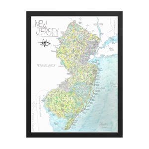 May include: A framed map of New Jersey, hand-drawn with colorful details. The map includes the state's borders, major cities, and surrounding states and oceans. The words "NEW JERSEY" are written at the top, with the artist's initials below.